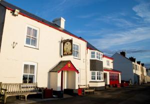 a building with a clock on the side of it at The Cricket Inn in Beesands