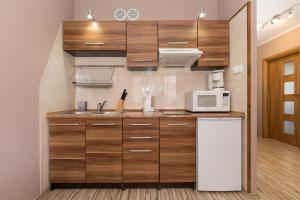 cocina con armarios de madera y microondas blanco en Apartamenty Villa Park by Renters, en Świnoujście