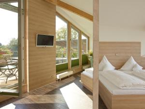 a bedroom with a bed and a tv on a wall at Hotel Forsthaus Grüna in Chemnitz