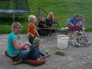 eine Gruppe von Menschen, die um ein Lagerfeuer sitzen in der Unterkunft Ferienhof Fink - Ferienwohnung Kleeblatt in Opfenbach + 1 Foto