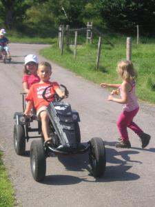 OpfenbachにあるFerienhof-Fink-Ferienwohnung-Kleeblattの二人の子供が道路でおもちゃ車に乗っている