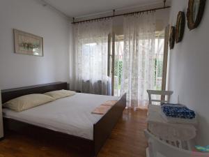 ein Schlafzimmer mit einem Bett und einem großen Fenster in der Unterkunft Charming Apartment in Vantacici amid the Sea in Dragozetići