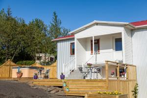 une maison avec une clôture en bois et une terrasse dans l'établissement Fagrahlíd Guesthouse, à Hvolsvöllur