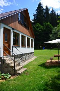 ein Haus mit einer Veranda und einer Bank davor in der Unterkunft Chata Nela in Horní Planá