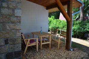 a wooden table and chairs under a pavilion at Chata Nela in Horní Planá