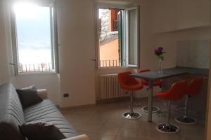 a living room with a couch and a table with red chairs at Casa Valli in Lezzeno