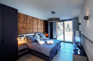 une chambre avec un lit et une grande fenêtre dans l'établissement Chalet Migui Luxury Living & Spa *****, Crans Montana, à Crans-Montana 42 autres photos