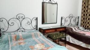 Schlafzimmer mit einem Bett, einer Kommode und einem Spiegel in der Unterkunft Two-Bedroom with Sea View Roof Top Chalet - Orora Village in Ain Suchna