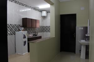 a kitchen with a refrigerator and a sink at Rayanat Abha Aparthotel in Abha