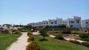 a walkway through a park in front of buildings at Two-Bedroom with Sea View Roof Top Chalet - Orora Village in Ain Sokhna