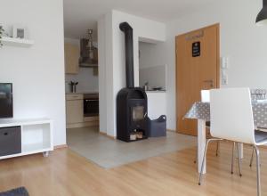 a kitchen with a stove in a living room at Ferienwohnung Familie Igel in Horgenzell