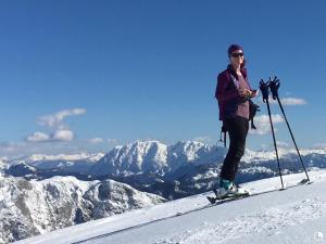 a woman on skis on top of a mountain at Alpine Appartments Ausseerland in Bad Aussee