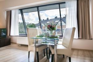 a dining room with a glass table and white chairs at VIP Apartamenty Szklane Domy The View in Zakopane