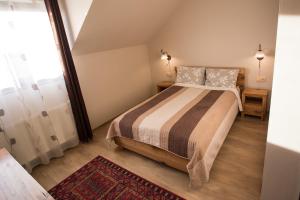 a small bedroom with a bed and a window at Pensiunea Brise in Medieşu Aurit