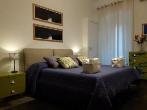 een slaapkamer met een bed met paarse lakens en kussens bij Kukkiti in Ragusa