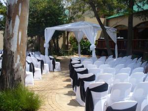 a row of white chairs and a white canopy at Picanha Grill Guest House & Events Venue in Nigel