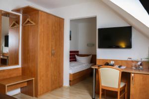 Zimmer mit einem Schreibtisch und einem Schlafzimmer mit einem Bett. in der Unterkunft City Hotel Journal in Wolfsburg