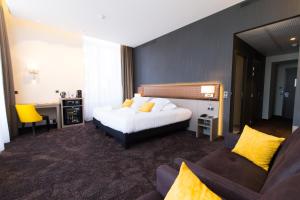 a hotel room with a bed and a couch at Les Jardins du Mess in Verdun-sur-Meuse