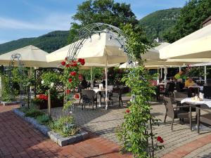 an outdoor patio with tables and chairs and flowers at Biosphärenhotel Graf Eberhard bei der Therme Bad Urach in Bad Urach