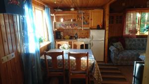 een keuken met een tafel en stoelen en een koelkast bij Ängsliden in Charlottenberg
