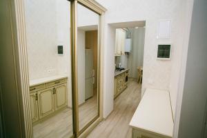 a bathroom with a large mirror and a sink at Apartment on Stefanyka 11 in Lviv