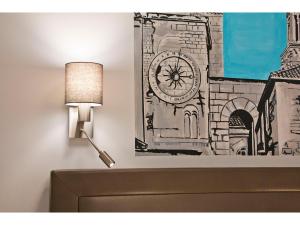 a drawing of a clock on a wall next to a lamp at IDRO Studio Apartments directly at the beach in Split