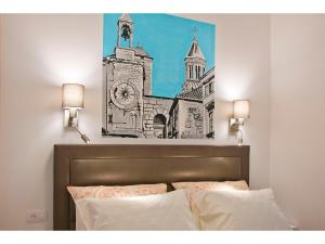 a painting of a church above a bed with two pillows at IDRO Studio Apartments directly at the beach in Split