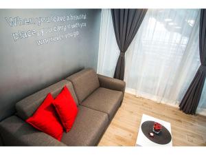 a couch with two red pillows in a living room at IDRO Studio Apartments directly at the beach in Split