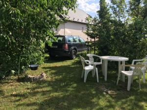 a table and chairs in a yard with a car at Ubytovanie v hosťovskom dome Flower in Veľký Meder