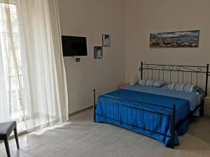 ナポリにあるCasa Fedoraのベッドルーム(青いシーツとテレビ付)