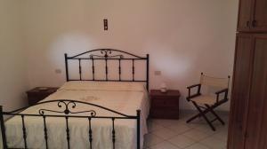 a bedroom with a black bed and a chair at Sweet Home in Quattro Pani