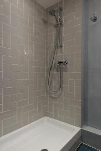a shower with a shower head in a bathroom at Hôtel Sanso by HappyCulture in Paris