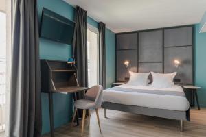 a bedroom with a bed and a desk and a chair at Hôtel Sanso by HappyCulture in Paris