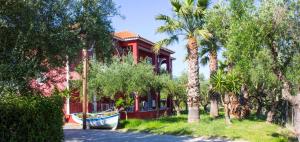 a red house with a boat in front of it at No Name Apartments in Laganas