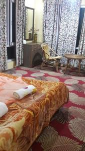 a bedroom with a bed and a chair and a mirror at Blooming Dale Hotel in Srinagar