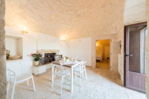 セルヴァ・ディ・ファザーノにあるTrulli Curriのキッチン、ダイニングルーム(白いテーブル、椅子付)