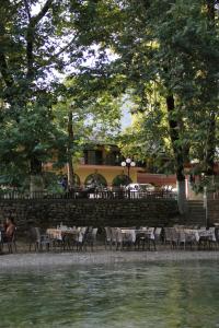 a restaurant with tables and chairs next to a body of water at Acherontas in Gliki