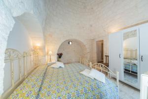 セルヴァ・ディ・ファザーノにあるTrulli Curriのベッドルーム1室(大型ベッド1台付)