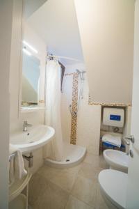 セルヴァ・ディ・ファザーノにあるTrulli Curriの白いバスルーム(洗面台、トイレ付)
