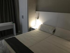 een slaapkamer met een groot wit bed in een kamer bij Hostal Boutique BBB Auto check in in Benidorm