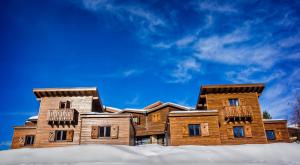 Casa de madera grande con nieve en el suelo en Le Loup Blanc en Pra-Loup