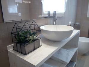ein Badezimmer mit einem weißen Waschbecken und einer Schüssel in der Unterkunft Pan di Zucchero in Cittadella