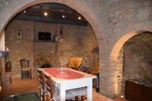 um quarto com uma mesa e uma parede de pedra em Apartment Casa Antica em Chianni