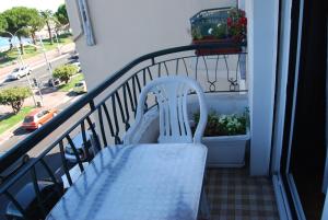 a white chair sitting on a balcony with a plant at Appart Nice Promenade in Nice