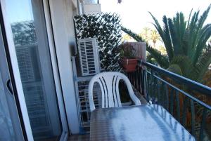 a table and chairs on a balcony with a window at Appart Nice Promenade in Nice