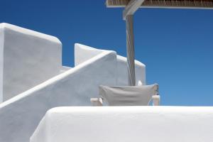two chairs sitting on top of a white building at Ploes Seaside Houses in Plaka