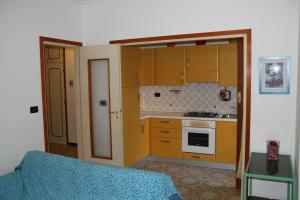 ボルディゲーラにあるbigarella 16のキッチン(黄色のキャビネット、青いソファ付)