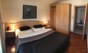 - une chambre avec un grand lit et 2 oreillers dans l'établissement Appartements Unterdorfer, à Altenmarkt im Pongau