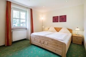 a bedroom with a bed and a window at Appartements Tannenhof in Wagrain +48 photos