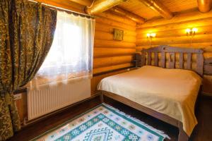 a bedroom with a bed and a window and a rug at Adelis in Yaremche